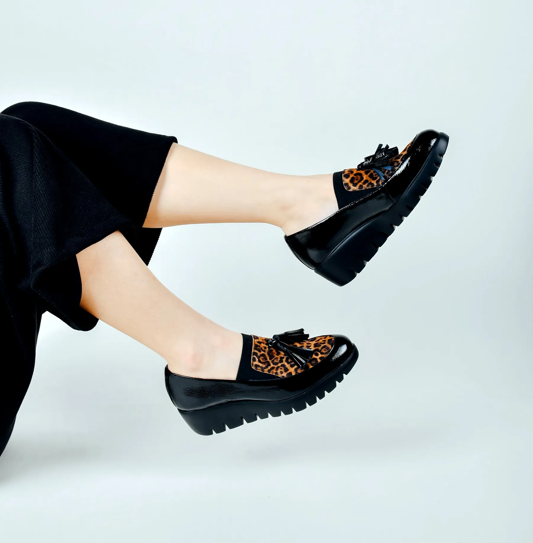 Modelo con zapatillas en fondo blanco.\n